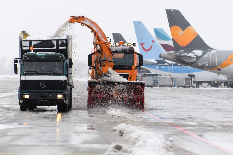Während das Gelände vom Schnee befreit wird, müssen zahlreiche Flugzeuge in München am Boden bleiben.