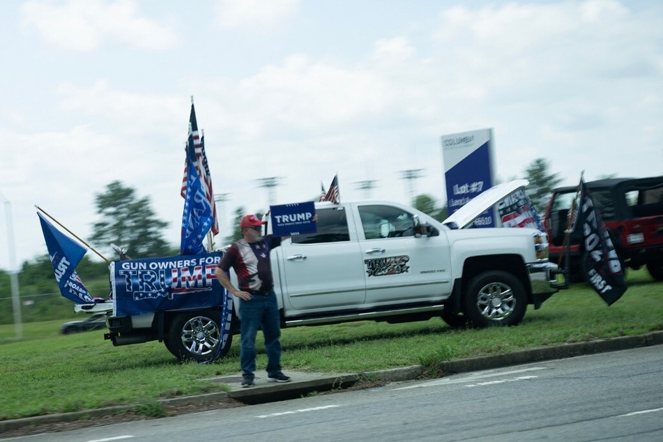 Supporters of former President Donald Trump watch a motorcade with President Joe Biden pass on July 6, 2023, in West Columbia, South Carolina.