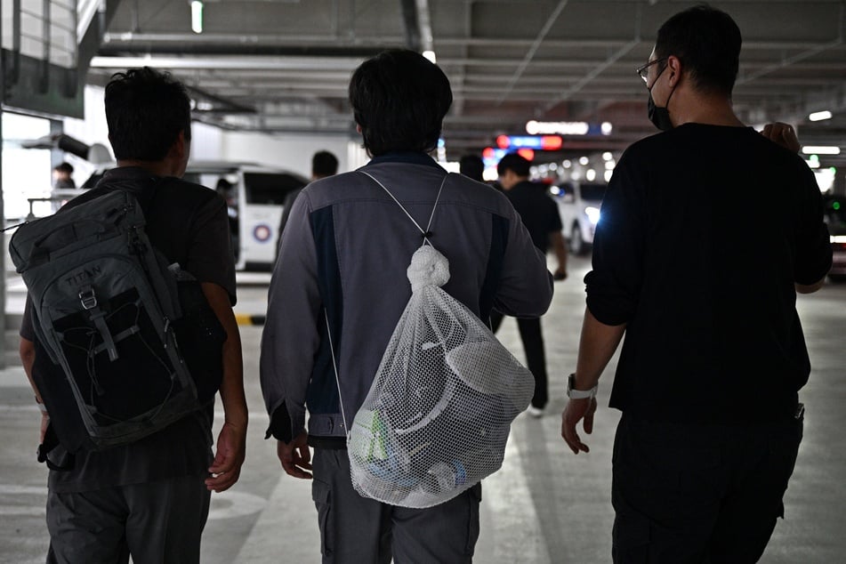 A South Korean man (c.) walks in a parking lot at Incheon International Airport on September 12, 2025, after arriving from Atlanta following his detention in an ICE raid at a Hyundai-LG plant in Ellabell, Georgia.