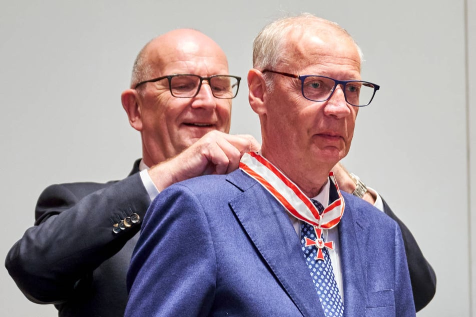Brandenburgs Ministerpräsident Dietmar Woidke (64, SPD, l.) hängt Günther Jauch (69) den Orden um.