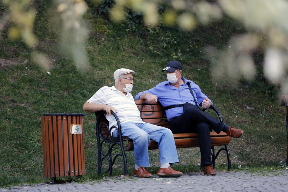Zwei Männer mit Gesichtsmasken sitzen auf einer Bank in einem Park. Die Türkei bestätigte am Freitag bereits mehr als 1.500 neue Coronavirus-Fälle.