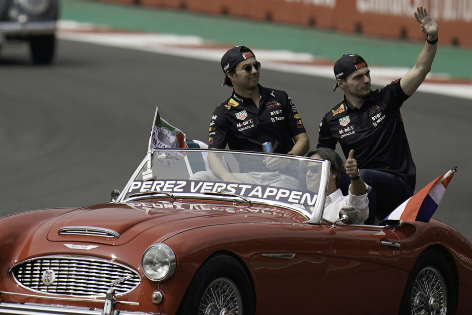 Während einer Parade vor dem Rennen winken Max Verstappen (25, rechts) und Sergio Perez (32) aus einem Auto.
