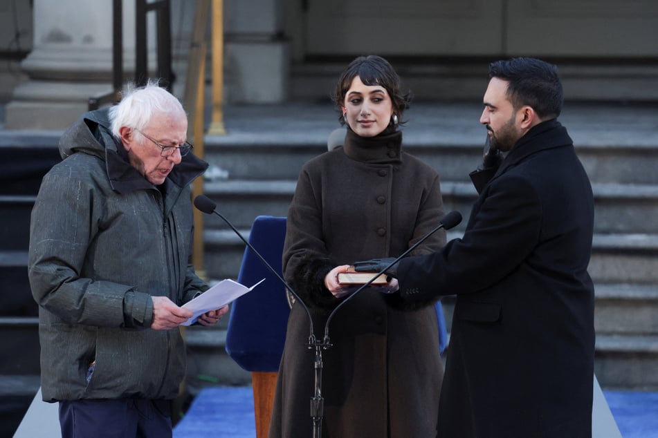 New York City Mayor Zohran Mamdani (r.), alongside his wife Rama Duwaji (c.), is sworn in by Senator Bernie Sanders during an inauguration ceremony on January 1, 2026.