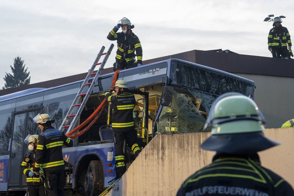 Einsatzkräfte der Feuerwehr arbeiten am verunglückten Bus in der Feldbergstraße.