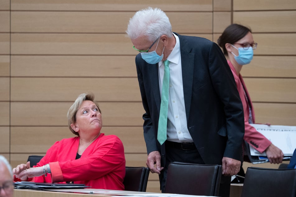 Susanne Eisenmann (CDU, l), Ministerin für Kultus, Jugend und Sport in Baden-Württemberg, unterhält sich während einer Plenarsitzung im Landtag von Baden-Württemberg mit Winfried Kretschmann (Bündnis 90/Die Grünen), Ministerpräsident von Baden-Württemberg.