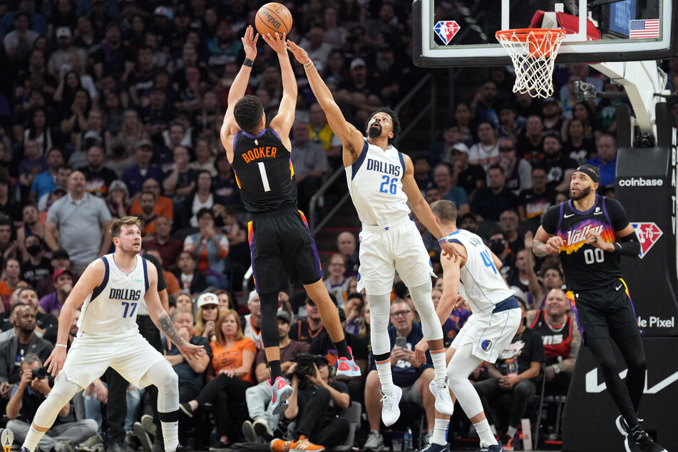 Devin Booker (2nd from l.) goes up to score against the Dallas Mavericks.