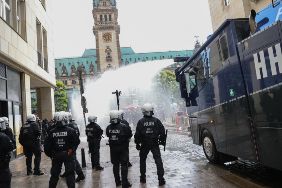 Polizeibeamte setzen nach einer aufgelösten Demonstration am Rathausmarkt einen Wasserwerfer ein. (Archivbild)
