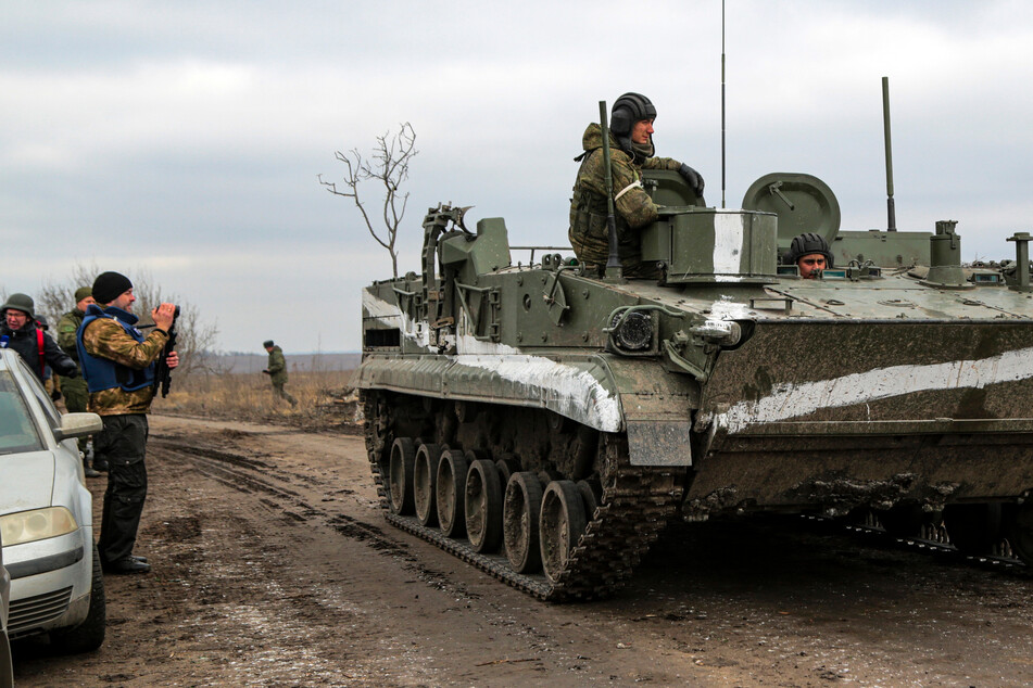 Mykolaivka: Ein Mann filmt ein gepanzertes Fahrzeug in der von prorussischen Kämpfern kontrollierten Region Donezk im Osten der Ukraine.