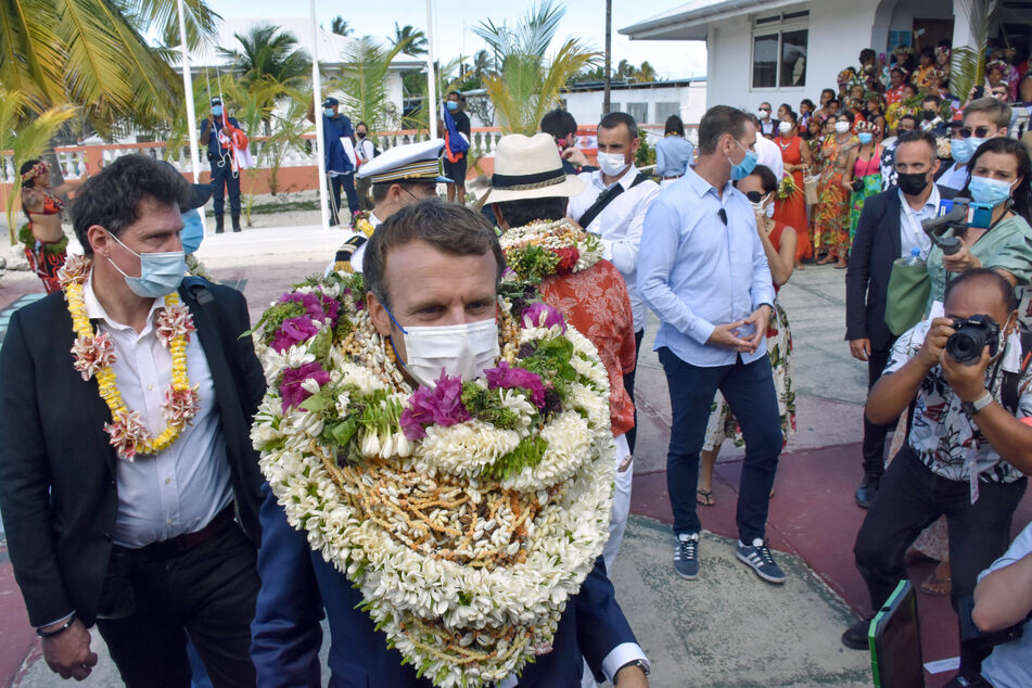 Emmanuel Macron trägt bei seiner Ankunft auf dem Manihi-Atoll, 500 km nordöstlich von Tahiti, Französisch-Polynesien im Pazifischen Ozean einen Blumenkranz und Muschelketten.
