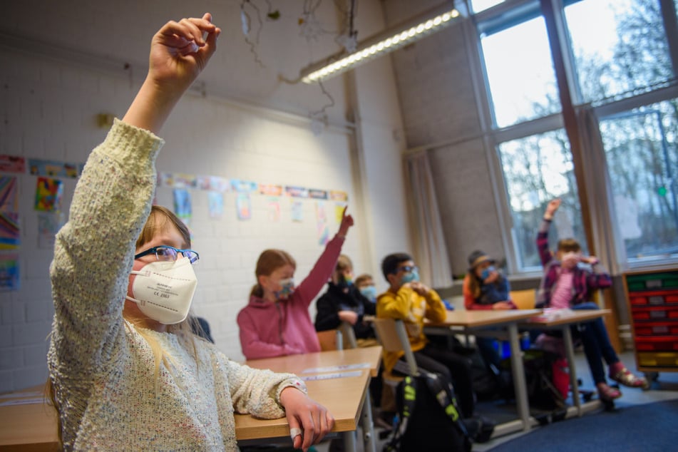 Eine Schülerin hebt an einer Grundschule in Kiel die Hand. Nach den Sommerferien soll an den Schulen die Normalität zurückkehren.
