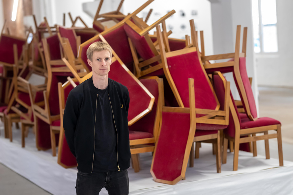 "Pochen"-Projektleiter Benjamin Gruner (31) vor dem Exponat "Sturzlage. Die Stühle vom Runden Tisch der DDR".