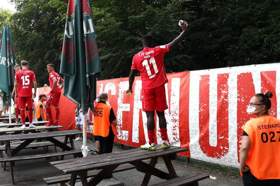 Anthony Ujah von Union Berlin feiert nach dem Spiel mit den Fans außerhalb des Platzes.