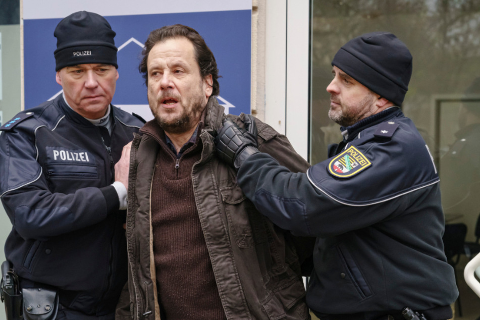 Der aufgebrachte Vater der Toten, Werner Mannfeld (Christian Kuchenbuch, 56), muss von der Polizei abgeführt werden.