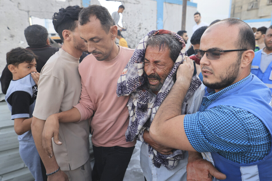 Mitarbeiter des UN-Palästinenserhilfswerks UNRWA helfen einem verletzten Mann. (Archivbild)