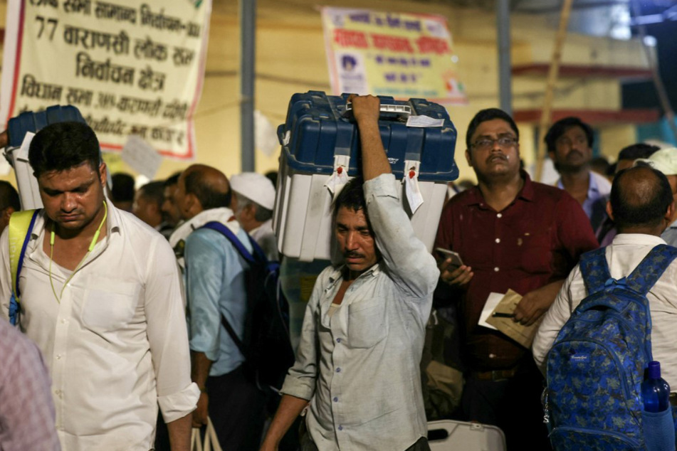 Erschöpfte Wahlhelfer treffen nach Abschluss der siebten und letzten Wahlphase in einem Sammelzentrum in Varanasi ein.