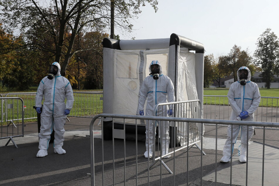 Medizinische Mitarbeiter der polnischen Armee zur Territorialverteidigung tragen bei der Arbeit in einer Drive-In-Teststation im Hauptquartier der Verteidigungstruppen Schutzanzüge.