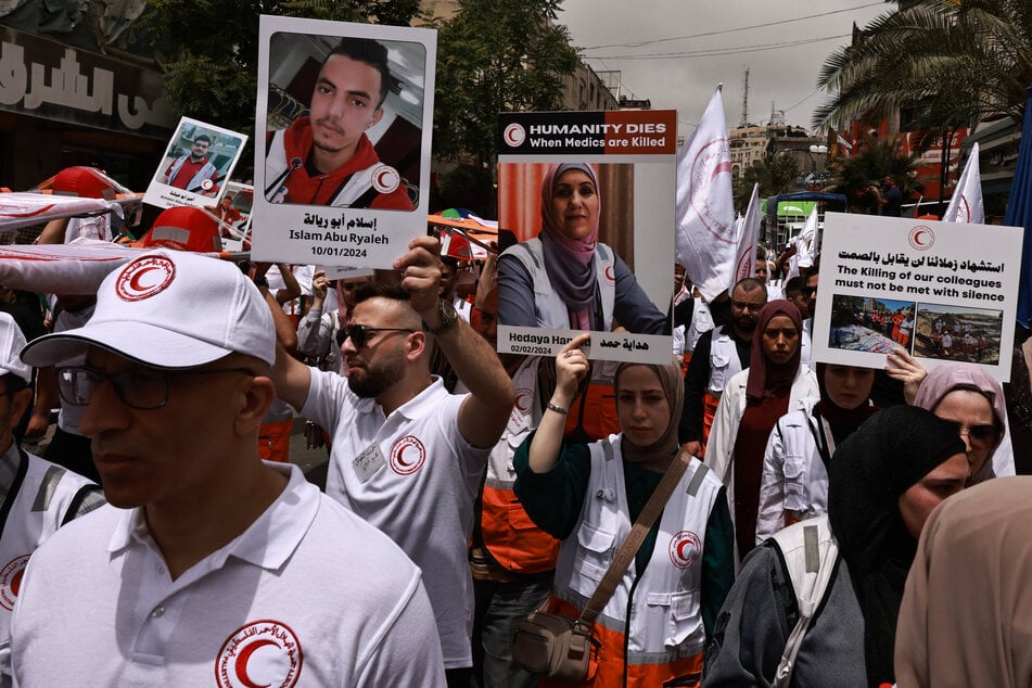 Palestinian Red Crescent crews call for the protection of medical personnel and humanitarian workers in Gaza during the Ramallah rally.
