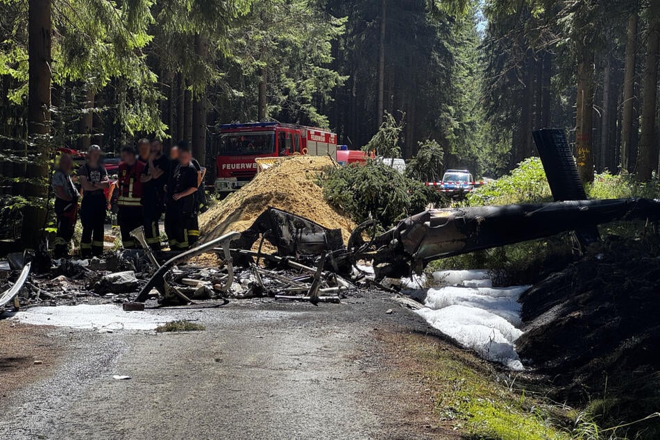 Das Wrack des abgestürzten Hubschraubers im Wald bei Sehmatal. Im Hintergrund ist der Kalkhaufen zu sehen und Äste.