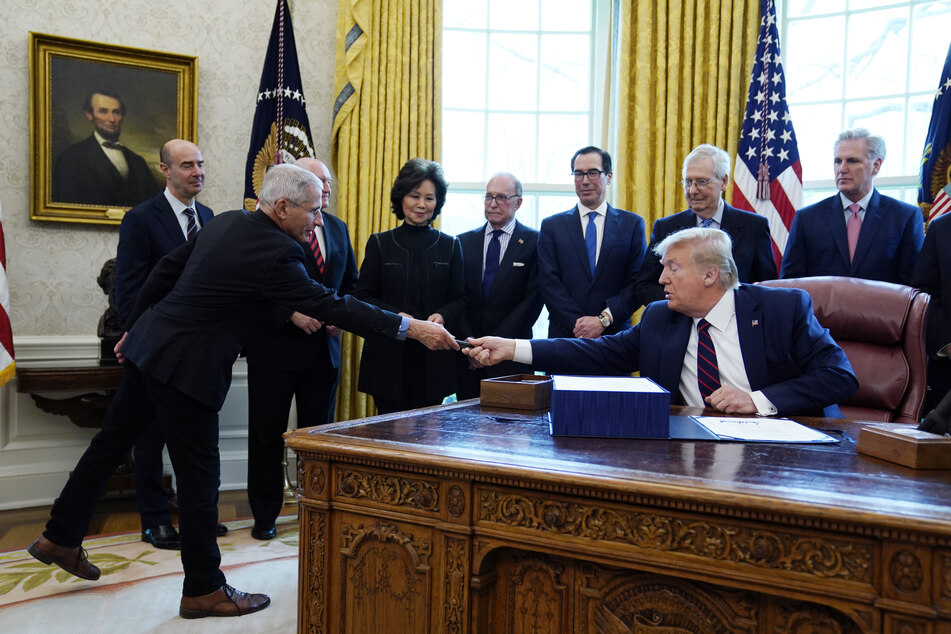 Am Freitag in Washington: Donald Trump (re.) überreicht Dr. Anthony Fauci (li.), dem Direktor des National Institute of Allergy and Infectious Diseases, einen Stift... Abstand: 2 Zentimeter.