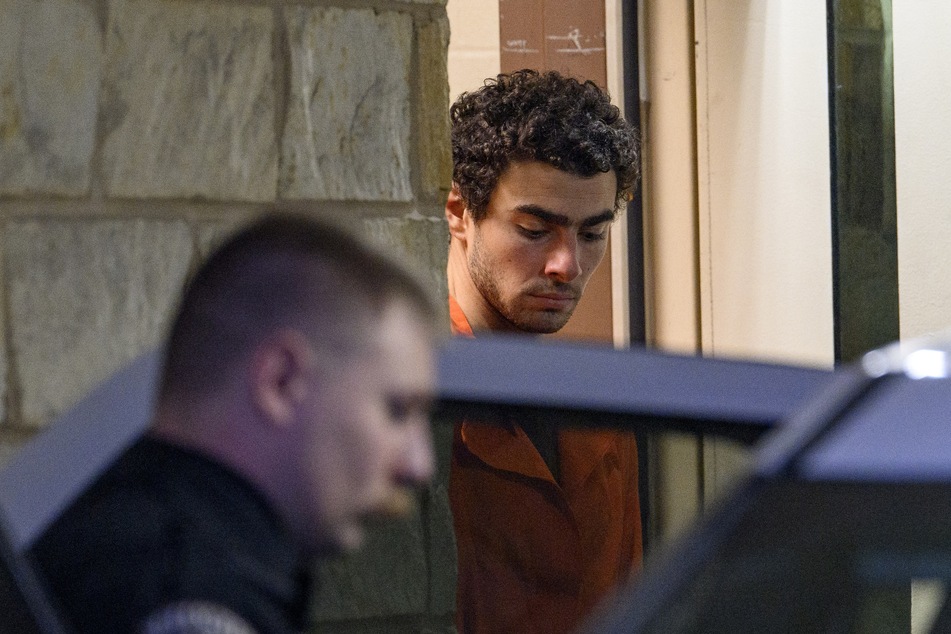 Suspected shooter Luigi Mangione (r.) is led from the Blair County Courthouse after an extradition hearing Tuesday in Hollidaysburg, Pennsylvania.