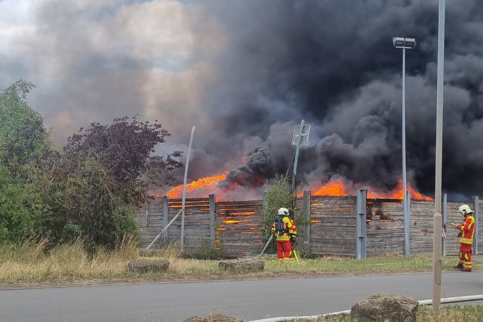 Die Einsatzkräfte kämpfen gegen die Flammen in der Deponie.