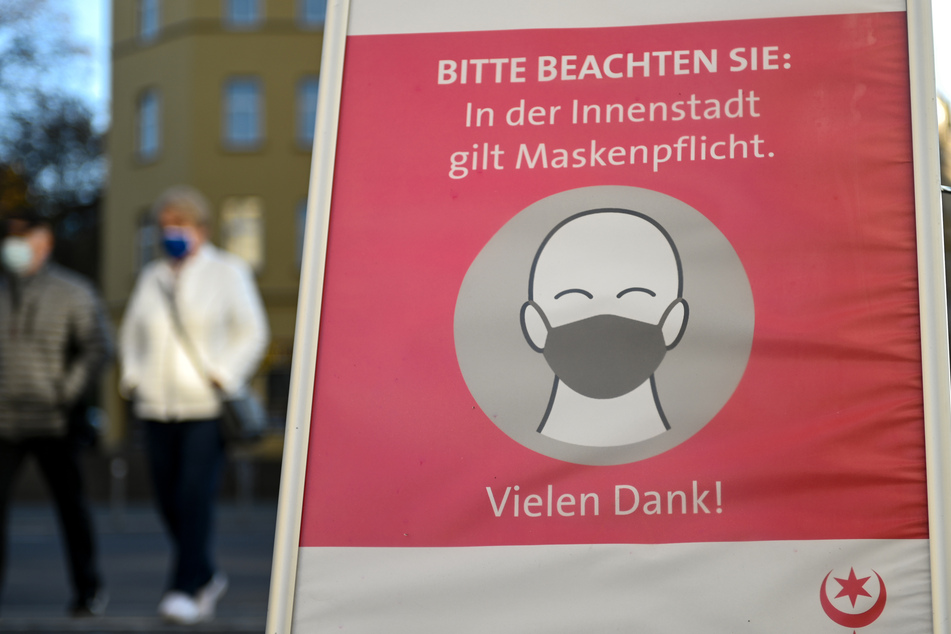 Ein Schild weißt auf die Maskenpflicht in der Hallenser Altstadt hin. Neue Plakate sollen nun dafür sensibilisieren, dass einige Menschen von eben dieser befreit sind.