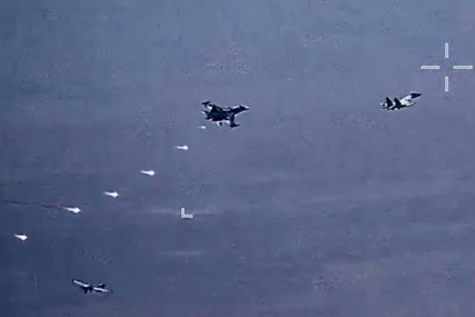Russische Jets werfen Täuschkörper (sogenannte Flares) über einer US-Drohne ab.