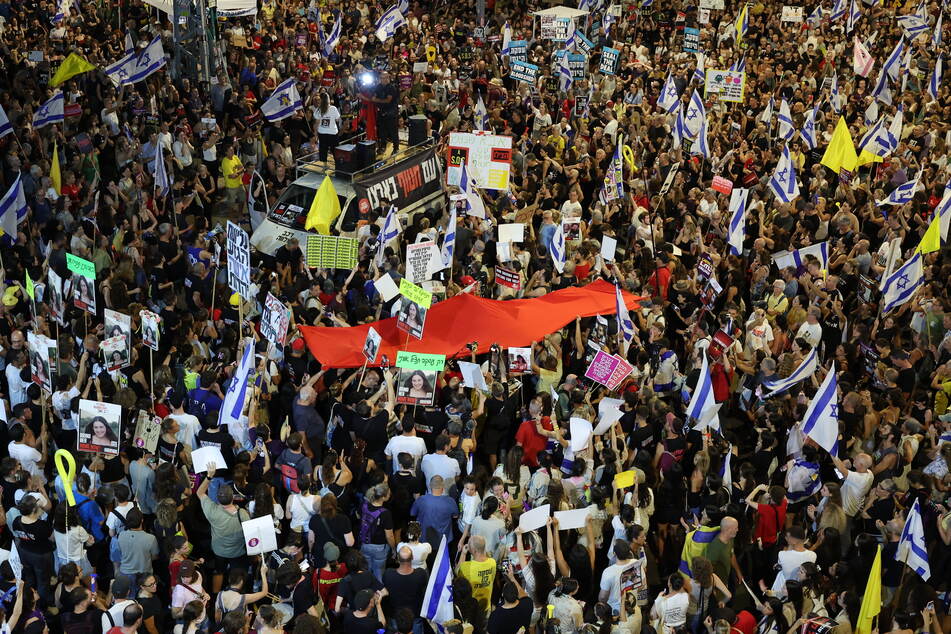 Demonstrators march during an anti-government protest calling for action to secure the release of Israeli hostages held captive since the October 7 attacks by Palestinian militants in the Gaza Strip, in the coastal city of Tel Aviv on Monday amid the ongoing conflict between Israel and the militant Hamas group.