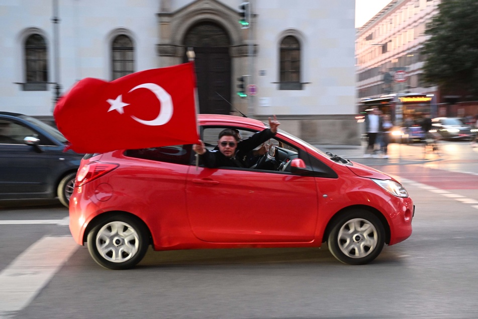 Ein Auto mit einer türkischen Flagge fährt über die Ludwigstraße in München, um den Ausgang der Wahl in der Türkei zu feiern.