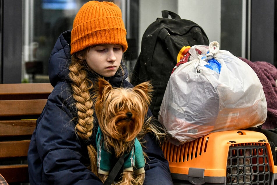 A girl holds a dog and cat as part of a convoy of 15 busses that traveled from Mariupol to evacuate Ukrainians.