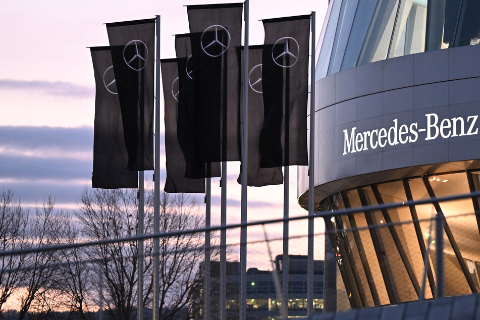 Fahnen mit dem Mercedes Stern, das Logo des Automobilherstellers Mercedes-Benz, stehen vor dem Mercedes-Benz Museum am Stammwerk in Stuttgart.