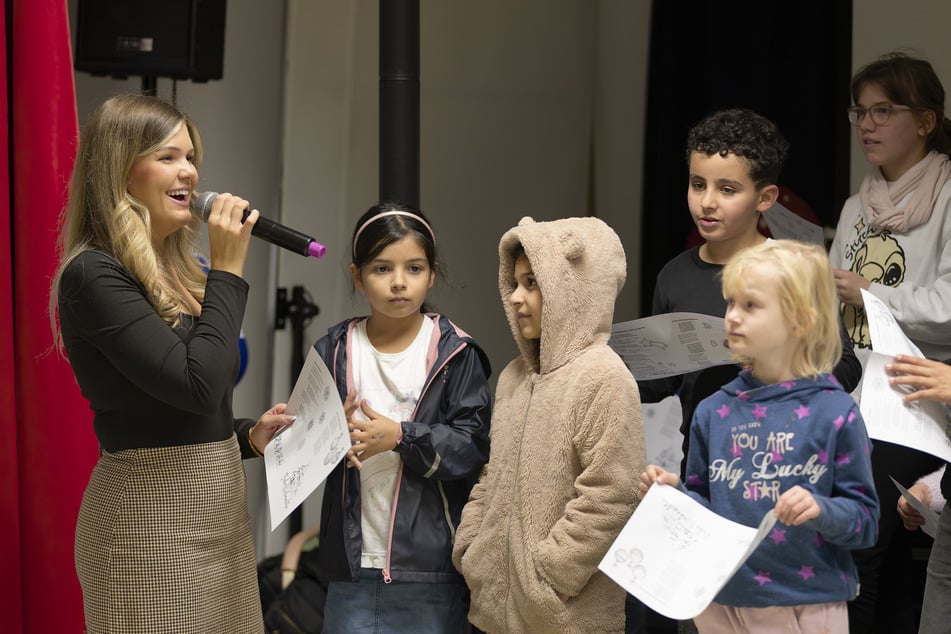 Linda Jung (27, l.) singt mit den "Arche"-Kindern das fröhliche Lied "In der Weihnachtsbäckerei".