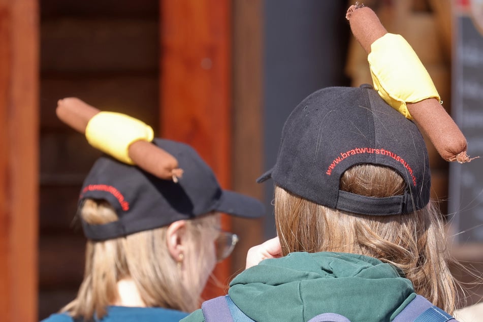 Besucher mit Bratwurstmützen befinden sich auf dem Gelände des Thüringer Bratwurstmuseums.