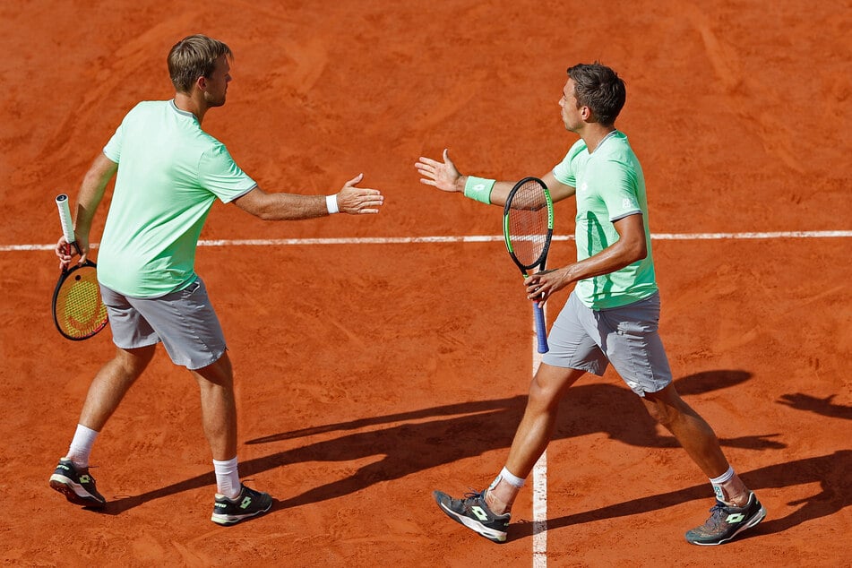 Kevin Krawietz (l) und Andreas Mies aus Deutschland klatschen sich in einem Turnier 2019 ab.