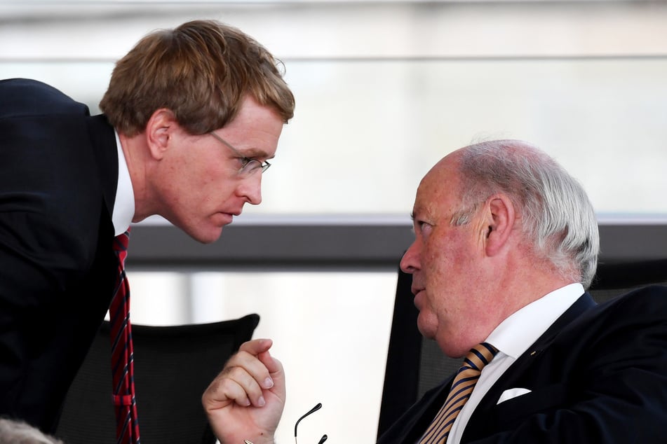 Daniel Günther (CDU,l), Ministerpräsident von Schleswig-Holstein, spricht bei einer Sitzung des schleswig-holsteinischen Landtags mit Hans-Joachim Grote (CDU).