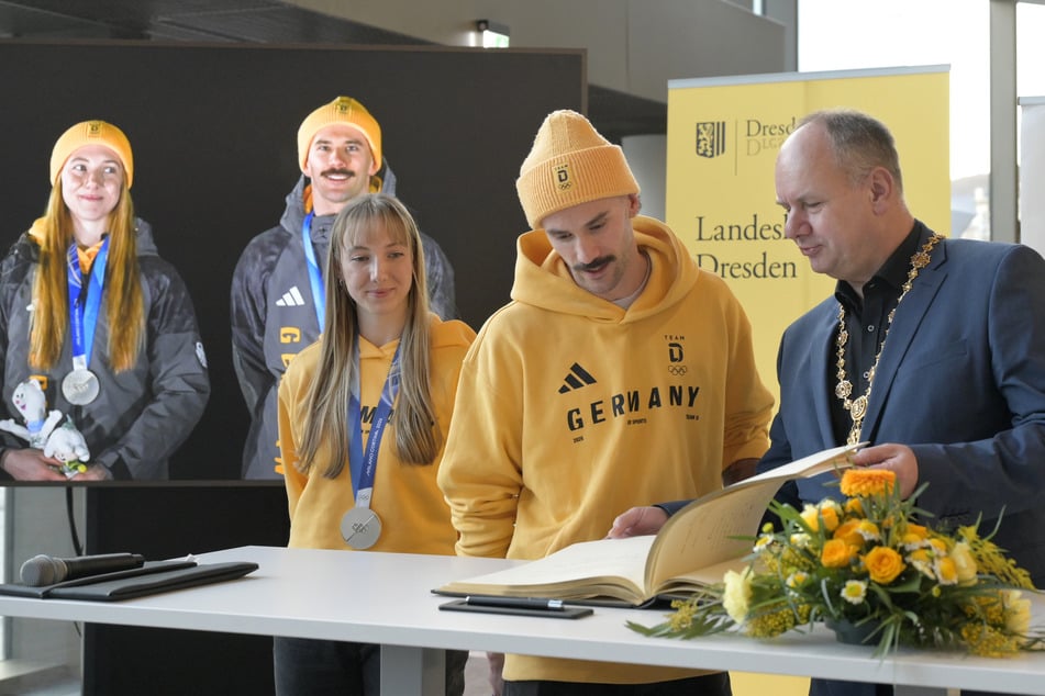 Susanne Kreher (27, l.) und Axel Jungk (34, M.) trugen sich unter den Augen von Dresdens OB Dirk Hilbert (54) ins Goldene Buch ein.