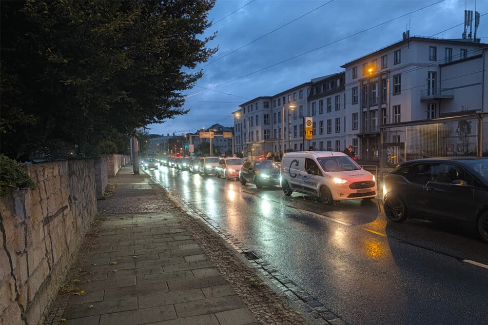 Blick auf die Haltestelle Angelikastraße und Autolichter in der Morgendämmerung.