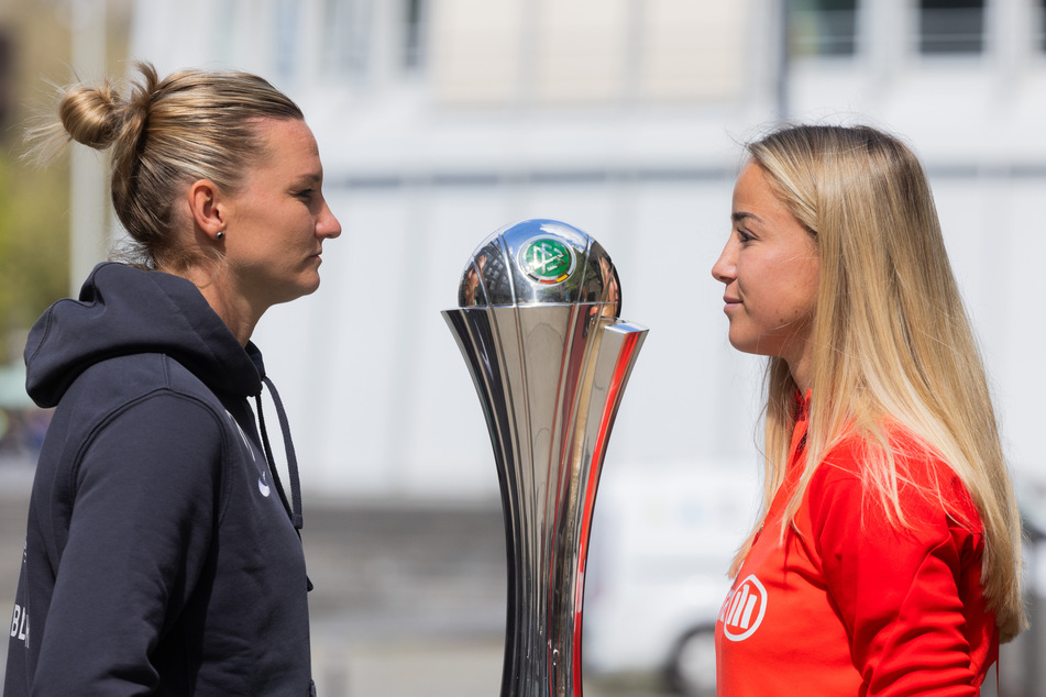 Alexandra Popp (33, l.) vom VfL Wolfsburg und Giulia Gwinn (24) vom FC Bayern München posieren neben dem DFB-Pokal.