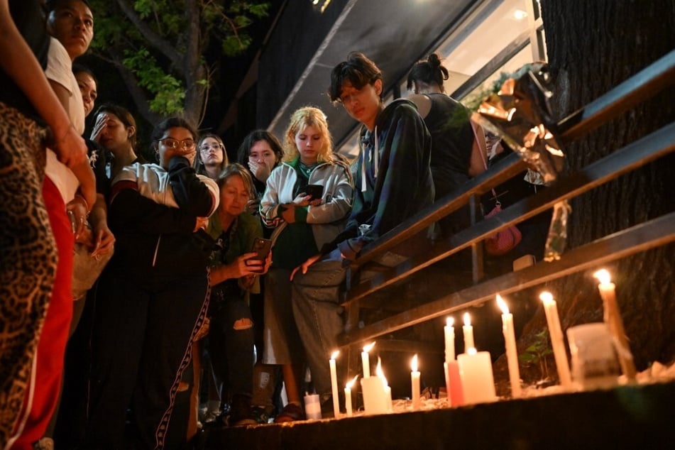 Fans of Liam Payne light candles next to the hotel where he died in Buenos Aires, Argentina.