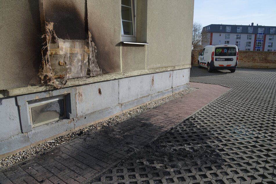 Nach dem Feuer in der Werdauer Straße in Zwickau wurde der ausgebrannte Opel abgeschleppt. Die Schäden am Wohnhaus sind noch sichtbar.