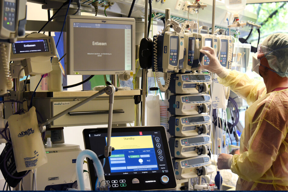 Ein Fachkrankenpfleger überprüft die Geräte auf einer Corona-Intensivstation.