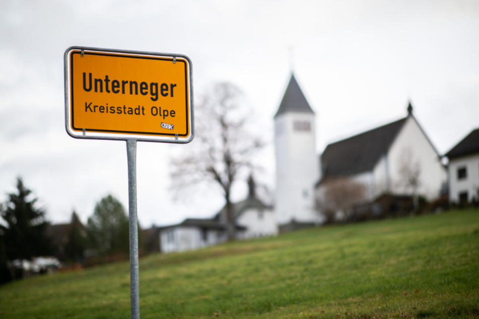 Das Ortsschild des Ortsteils Unterneger steht vor der St. Barbara- und St. Luzia-Kirche.