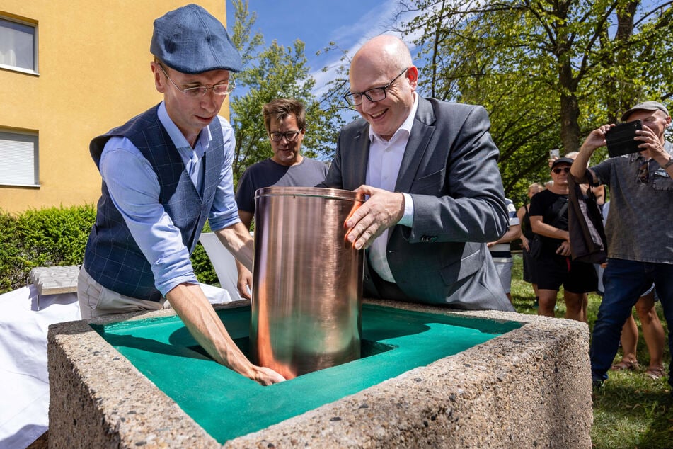 Initiator Historiker Norbert Engst (40, l.) und Sven Schulze (52, SPD, r.) versenken die neu befüllte Kapsel im Grundstein.