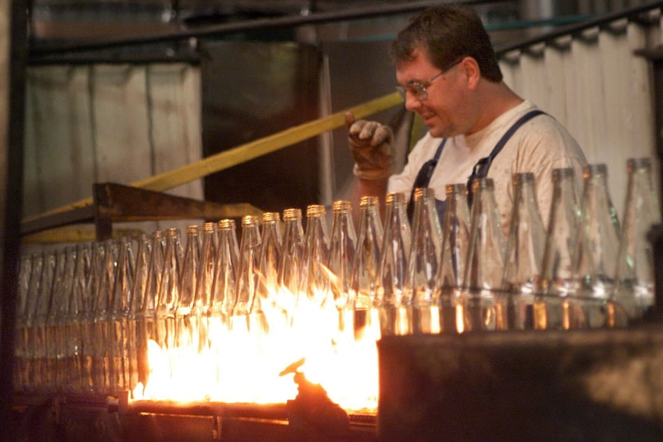 Ein Mitarbeiter überwacht im Glaswerk die Produktion von Flaschenrohlingen. Die Anfänge der Glasproduktion in Freital gehen ins Jahr 1802 zurück.