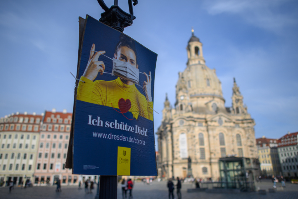 Das offizielle Plakat der Landeshauptstadt Dresden, welches auf die Nutzung von Mund-Nasen-Masken hinweist, hängt an einer Laterne auf dem Neumarkt vor der Frauenkirche.