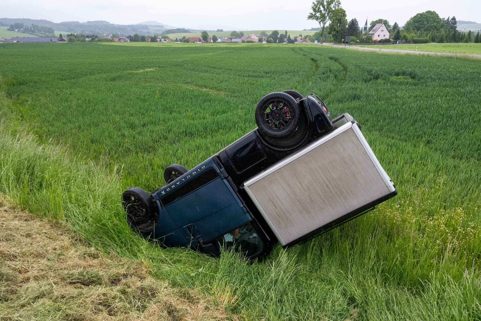 Ein Mopedauto ist kopfüber auf dem Feld gelandet.