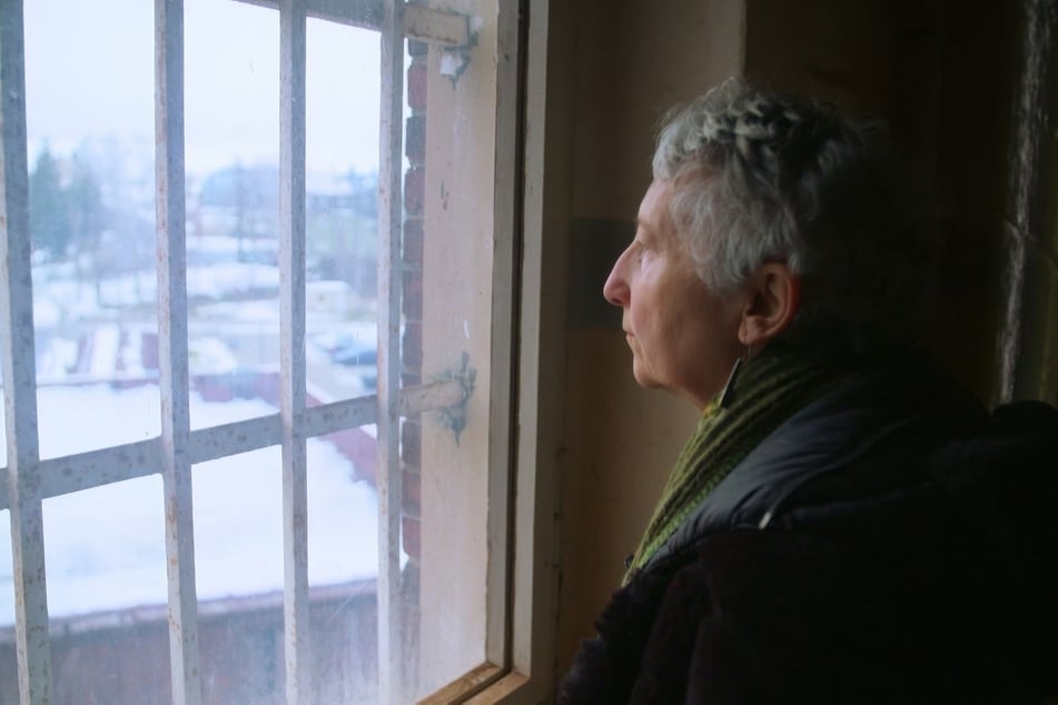 Gabriele Stötzer (72) blickt durch die Gitter des ehemaligen Frauengefängnisses in Hoheneck. Sie erinnert sich an schreckliche, düstere Zeiten.