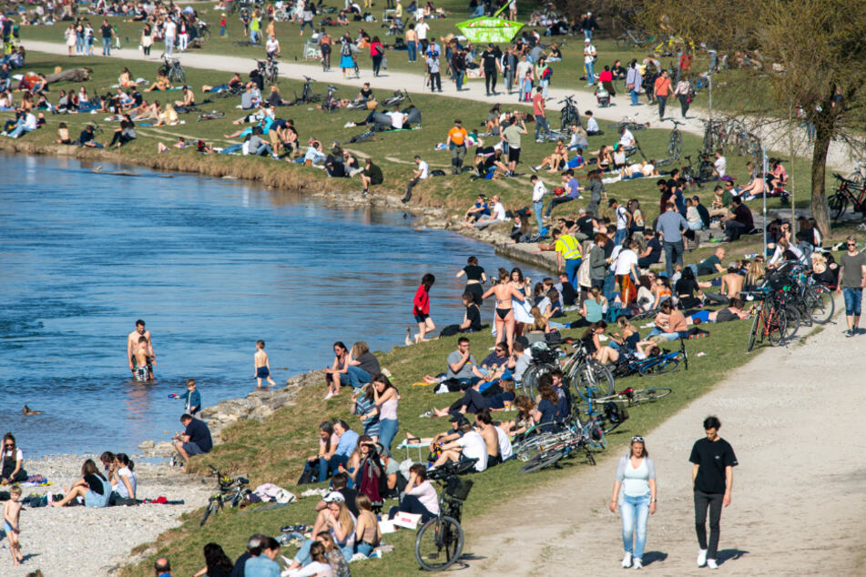 Hunderte Menschen halten sich bei Sonnenschein und warmen Frühlings-Temperaturen am Ufer der Isar zwischen Wittelsbacher Brücke und Reichenbachbrücke auf.