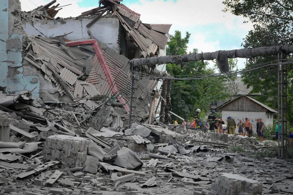 Rettungskräfte und Anwohner holen nach einem russischen Luftangriff in Lyssytschansk eine Leiche aus den Trümmern eines Gebäudes.
