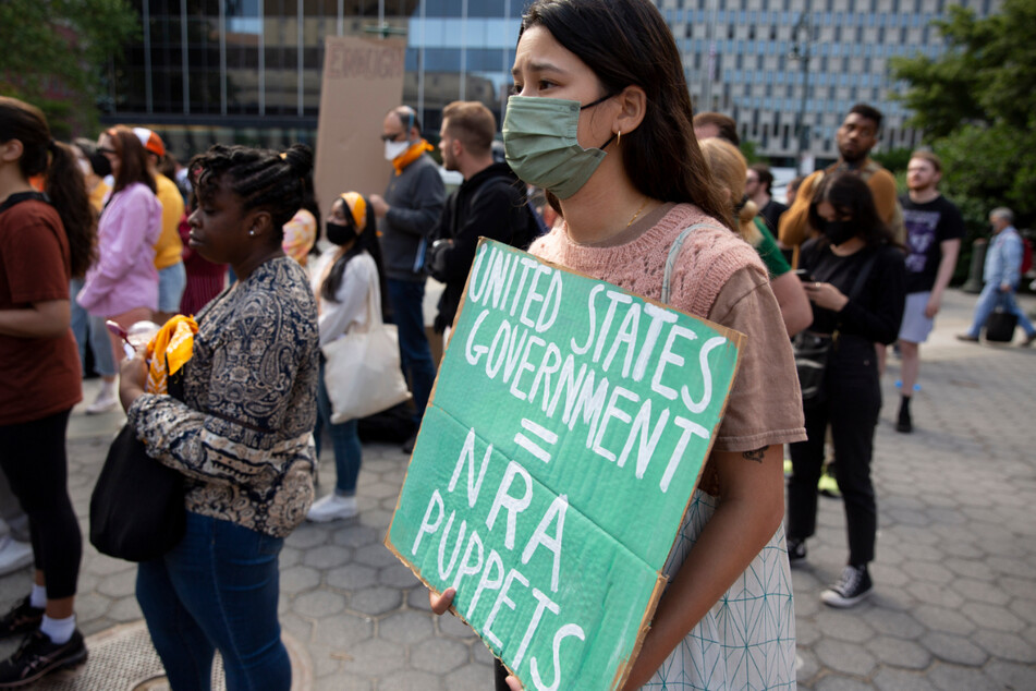 Eine Demonstrantin in New York hält ein Schild mit der Aufschrift "United States Government = NRA Puppets" (Regierung der USA = Marionetten der NRA) in den Händen.